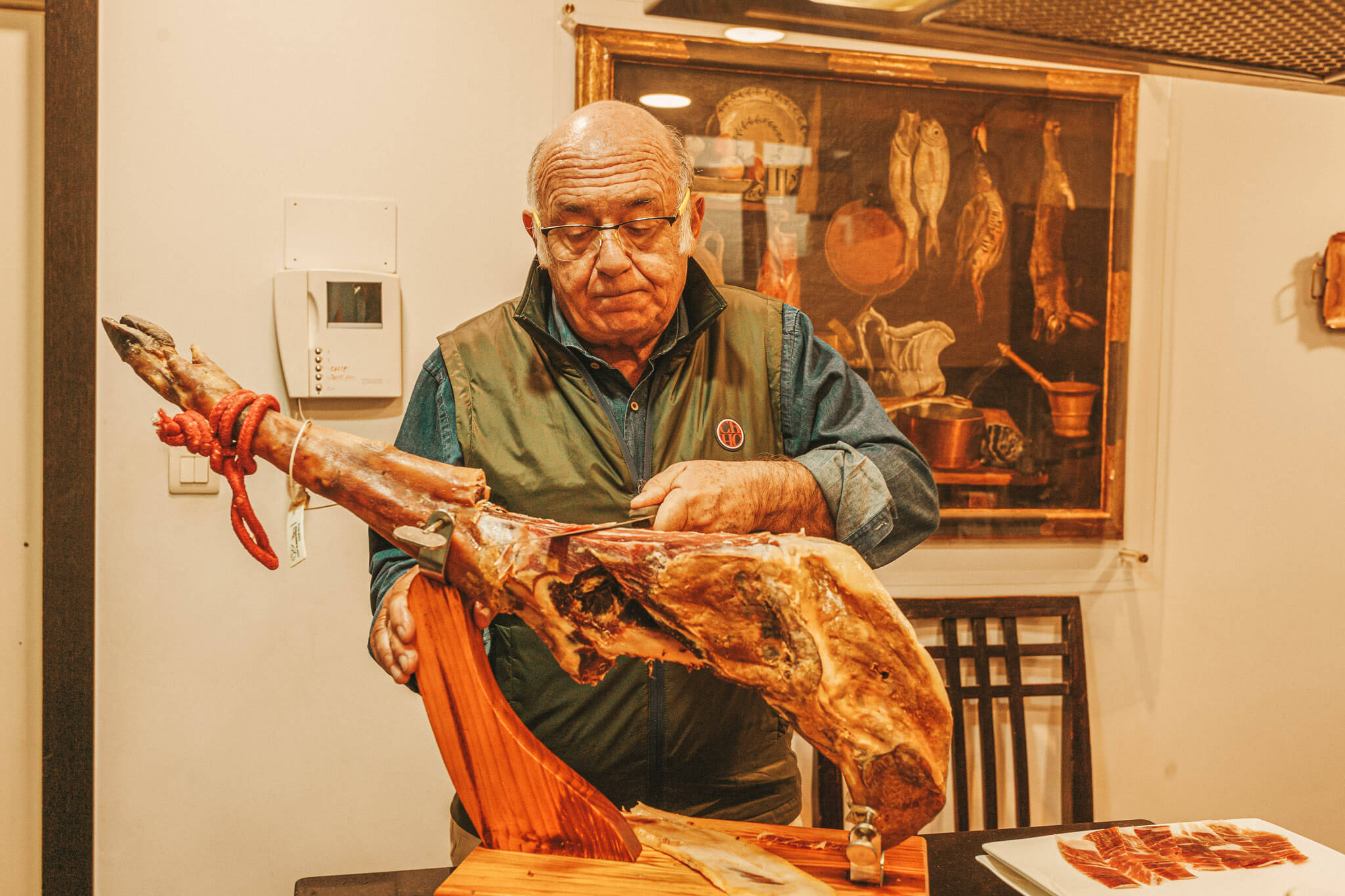 A host slices his jamón ibérico to serve it in his home in Granada.